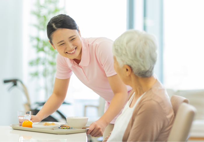配膳を行う介護士とご利用者様